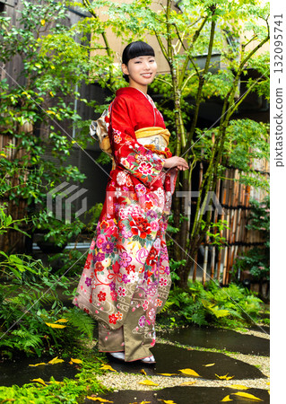 Japanese woman wearing a furisode kimono standing in the garden 132095741