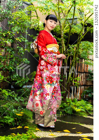 Japanese woman wearing a furisode kimono standing in the garden 132095742