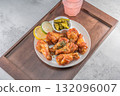 Savor the irresistible allure of these delicious, spicy buffalo chicken wings. Crispy, cooked to perfection and coated in a flavorful sauce, they are sprinkled with sesame seeds 132096007