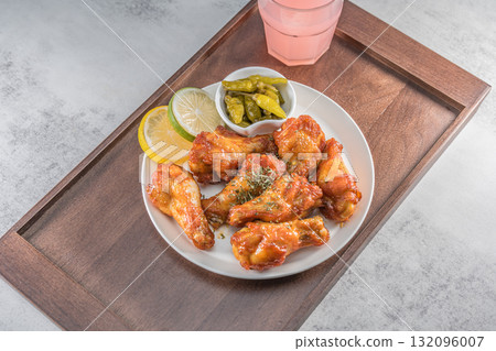 Savor the irresistible allure of these delicious, spicy buffalo chicken wings. Crispy, cooked to perfection and coated in a flavorful sauce, they are sprinkled with sesame seeds Savor the irresistible allure of these delicious, spicy buffalo chicken wings. Crispy, cooked to perfection and coated in a flavorful sauce, they are sprinkled with sesame seeds 132096007