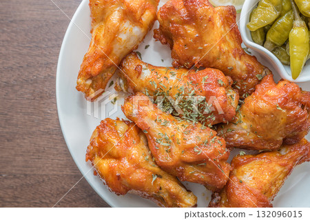 Savor the irresistible allure of these delicious, spicy buffalo chicken wings. Crispy, cooked to perfection and coated in a flavorful sauce, they are sprinkled with sesame seeds 132096015