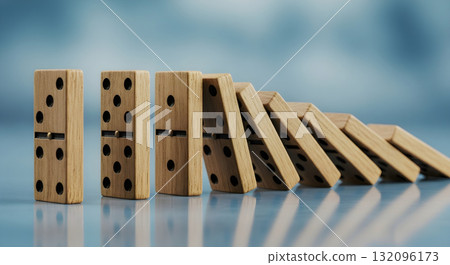 Domino effect concept with wooden dominoes falling in a row. 132096173