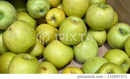 A vibrant and colorful display of fresh, crisp green apples organized neatly in a bustling market settings. Close-up. A vibrant and colorful display of fresh, crisp green apples organized neatly in a bustling market settings. Close-up. 132097373