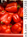 Vibrant red bell peppers are abundant in a market basket, showcasing their freshness and vivid color. Close-up. 132097388
