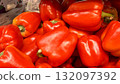 Vibrant red bell peppers are abundant in a market basket, showcasing their freshness and vivid color. Close-up. 132097392