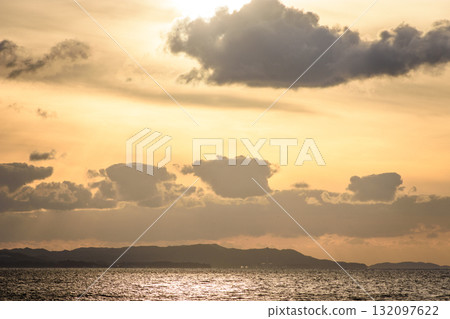 Serene Sunset Over Ocean with Silhouetted Hills Serene Sunset Over Ocean with Silhouetted Hills 132097622