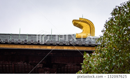 Golden ornament on traditional Japanese temple roof 132097625