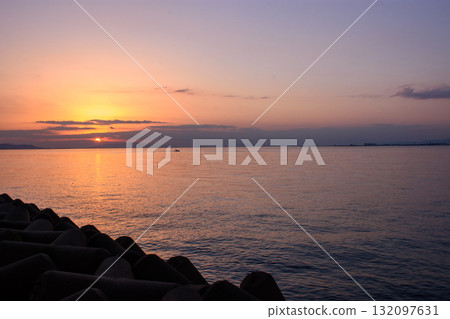 Serene Sunset Over Ocean with Breakwater 132097631