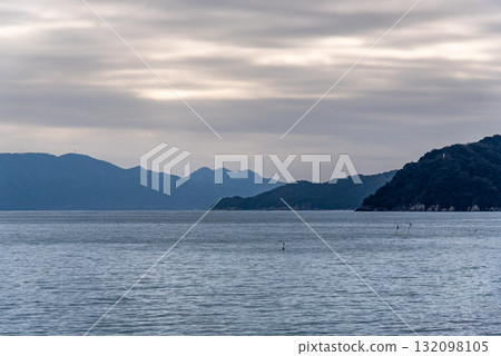 Serene Seascape with Distant Mountains Serene Seascape with Distant Mountains 132098105