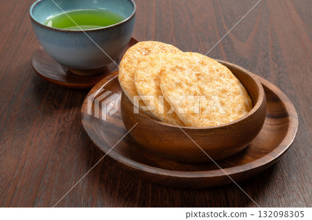 Soy sauce rice crackers and green tea on a black background Soy sauce rice crackers and green tea on a black background 132098305