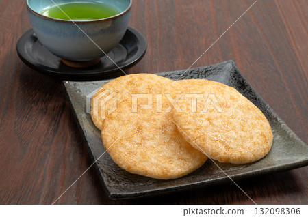 Soy sauce rice crackers and green tea on a black background 132098306