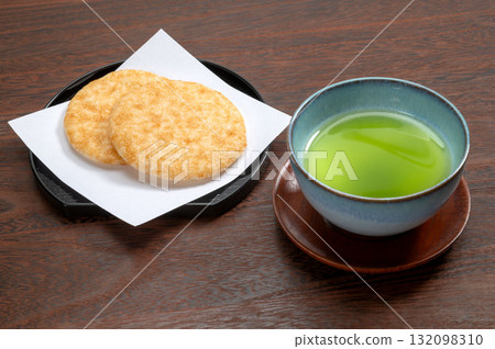 黑色背景中的醬油米餅和綠茶 黑色背景中的醬油米餅和綠茶 132098310