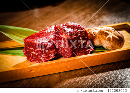 Raw meat and shiitake mushrooms lined up on a wooden tray - ingredients for yakiniku Raw meat and shiitake mushrooms lined up on a wooden tray - ingredients for yakiniku 132098623