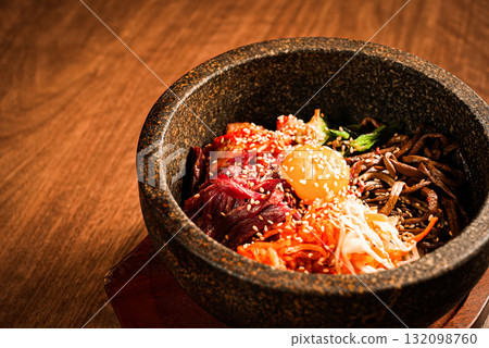石鍋拌飯，一道經典的韓國菜餚，上面放有蛋黃和蔬菜 132098760