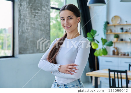 Portrait of confident successful teenage girl posing with crossed arms at home 132099042