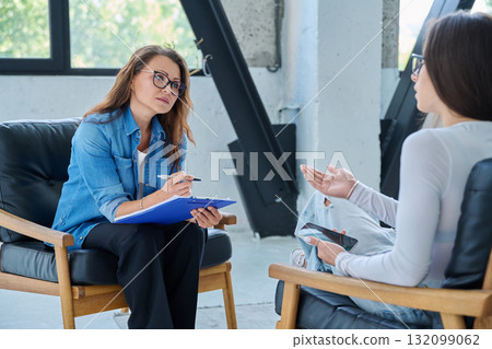 Middle aged professional female psychologist, counselor working with young woman 132099062
