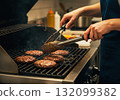 A woman grills burger meat 132099382