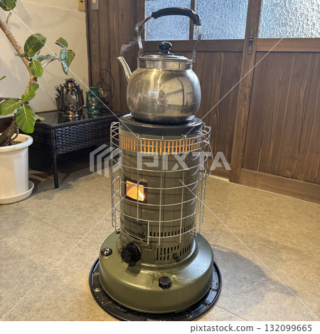 A kettle steams on a retro kerosene stove A kettle steams on a retro kerosene stove 132099665