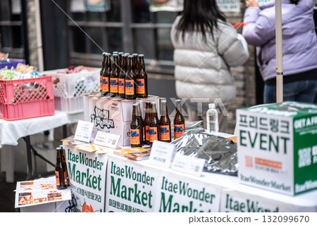 Outdoor market stall with beverages and products, people browsing Itaewon World Market festival in Seoul, South Korea 132099670