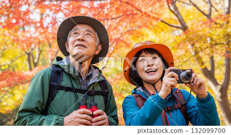 Senior couple hiking through autumn leaves Senior couple hiking through autumn leaves 132099700