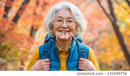 一位 70 多歲的老人在秋葉中健行 132099756