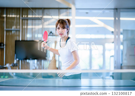attractive asian woman playing table tennis ( ping pong ) in sport club attractive asian woman playing table tennis ( ping pong ) in sport club 132100817