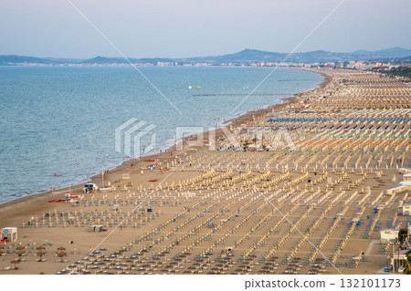 Wide sandy sea beach with sun loungers and umbrellas view from above. Evening on Rimini Italy coast resort 132101173
