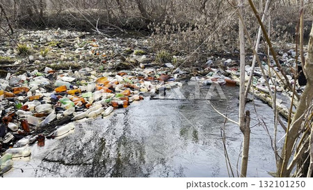 Dirty river is polluted with many plastic bottles. A lot of trash is dumped in open and freely available places at nature. Global environmental pollution problem. Concept of ecological disaster Dirty river is polluted with many plastic bottles. A lot of trash is dumped in open and freely available places at nature. Global environmental pollution problem. Concept of ecological disaster 132101250