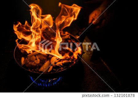 Chef Cooking with Fire Flame in frying iron pan Chef Cooking with Fire Flame in frying iron pan 132101878