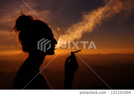 silhouette of smoking woman in sunset landscape silhouette of smoking woman in sunset landscape 132101894