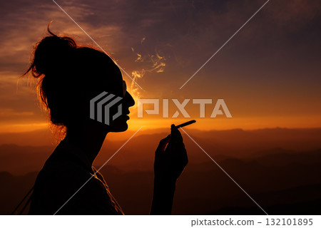 silhouette of smoking woman in sunset landscape silhouette of smoking woman in sunset landscape 132101895