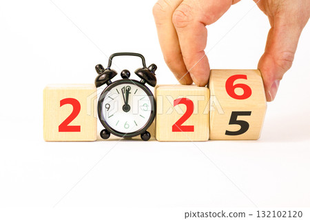 Business concept of 2026 new year symbol. Businessman turns wooden cube and changes number 2025 to 2026. Alarm clock. Beautiful white background, copy space. Business 2026 happy new year concept. Business concept of 2026 new year symbol. Businessman turns wooden cube and changes number 2025 to 2026. Alarm clock. Beautiful white background, copy space. Business 2026 happy new year concept. 132102120
