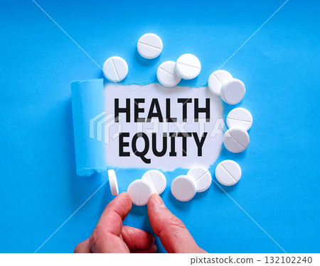 Health equity symbol. Concept words Health equity on beautiful white paper. White pills tablets. Doctor's hand. Beautiful blue background. Medical healthy lifestyle health equity concept. 132102240