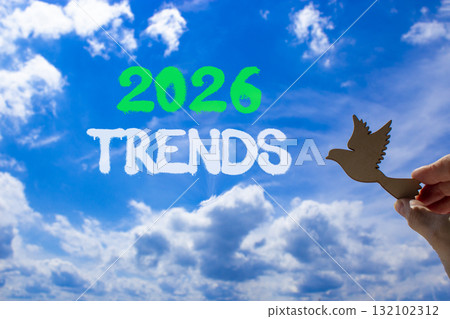 2026 Trends new year symbol. Concept words 2026 Trends on beautiful blue sky. Beautiful blue sky background. Businessman's hand holds wooden bird. Business and 2026 Trends new year concept. Copy space 132102312