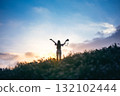 silhouette of happy woman relaxing on mountain hill  in summer sunset sky happy girl enjoying freedom and life raising arms feeling free 132102444
