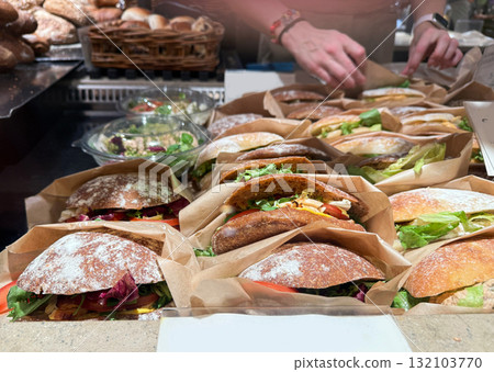 Row of freshly wrapped club sandwiches on cafe counter. Row of freshly wrapped club sandwiches on cafe counter. 132103770
