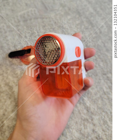 Lint Remover Device Held in Hand Close-up 132104351
