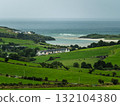 A beautiful view of the countryside in West Cork, Ireland, with green farmland, houses, a beach and the Atlantic Ocean. 132104380