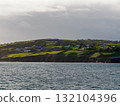 Beautiful irish coastal scenery featuring rolling green hills and houses at Dunmore Bay Beach, Ireland. 132104396