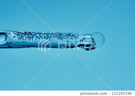 Gel hyaluronic serum in a pipette on a blue background. Gel hyaluronic serum in a pipette on a blue background. 132105190