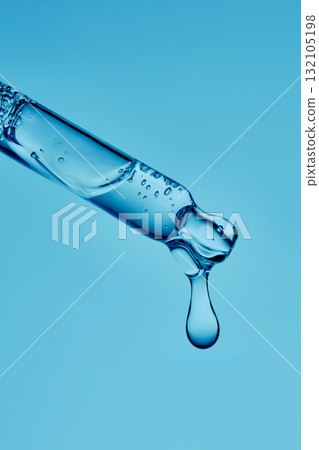A serum pipette with lots of bubbles on a blue background. 132105198