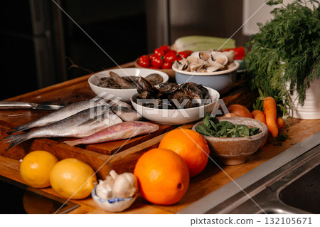 Sea bream and shells on the table next to vegetables 132105671