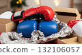 Red and blue boxing gloves on packaging paper with boxes in background for gift or sport theme Red and blue boxing gloves on packaging paper with boxes in background for gift or sport theme 132106057