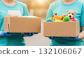 Volunteers holding boxes of donations with toys and food for charity support Volunteers holding boxes of donations with toys and food for charity support 132106067