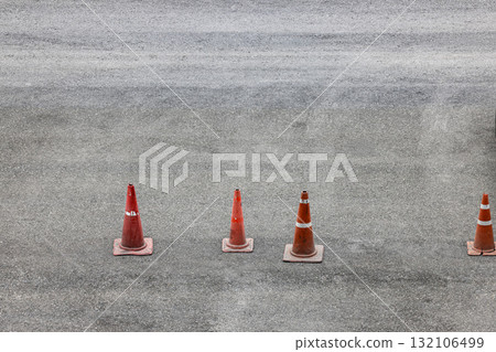 row of orange fluorescent, reflex traffic cones on road. row of orange fluorescent, reflex traffic cones on road. 132106499