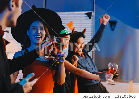 Joyful office Halloween party with coworkers in costumes, celebrating with drinks and laughter, fostering teamwork and festive spirit 132106666