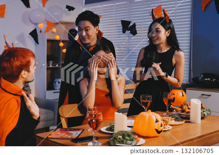 Joyful office Halloween party with coworkers in costumes, celebrating with drinks and laughter, fostering teamwork and festive spirit 132106705