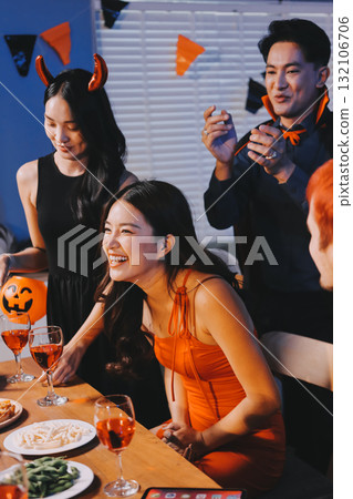 Joyful office Halloween party with coworkers in costumes, celebrating with drinks and laughter, fostering teamwork and festive spirit 132106706