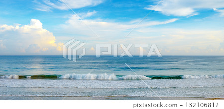 Tranquil Seascape With Gentle Waves Rolling Onto Sandy Beach Under Clear Blue Sky Horizontal 132106812