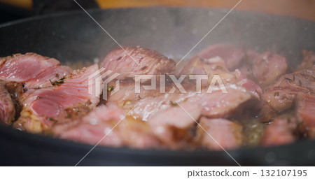 Delicious Juicy Beef Meat Cooking on Pan Seasoned Herbs. Delicious Juicy Beef Meat Cooking on Pan Seasoned Herbs. 132107195